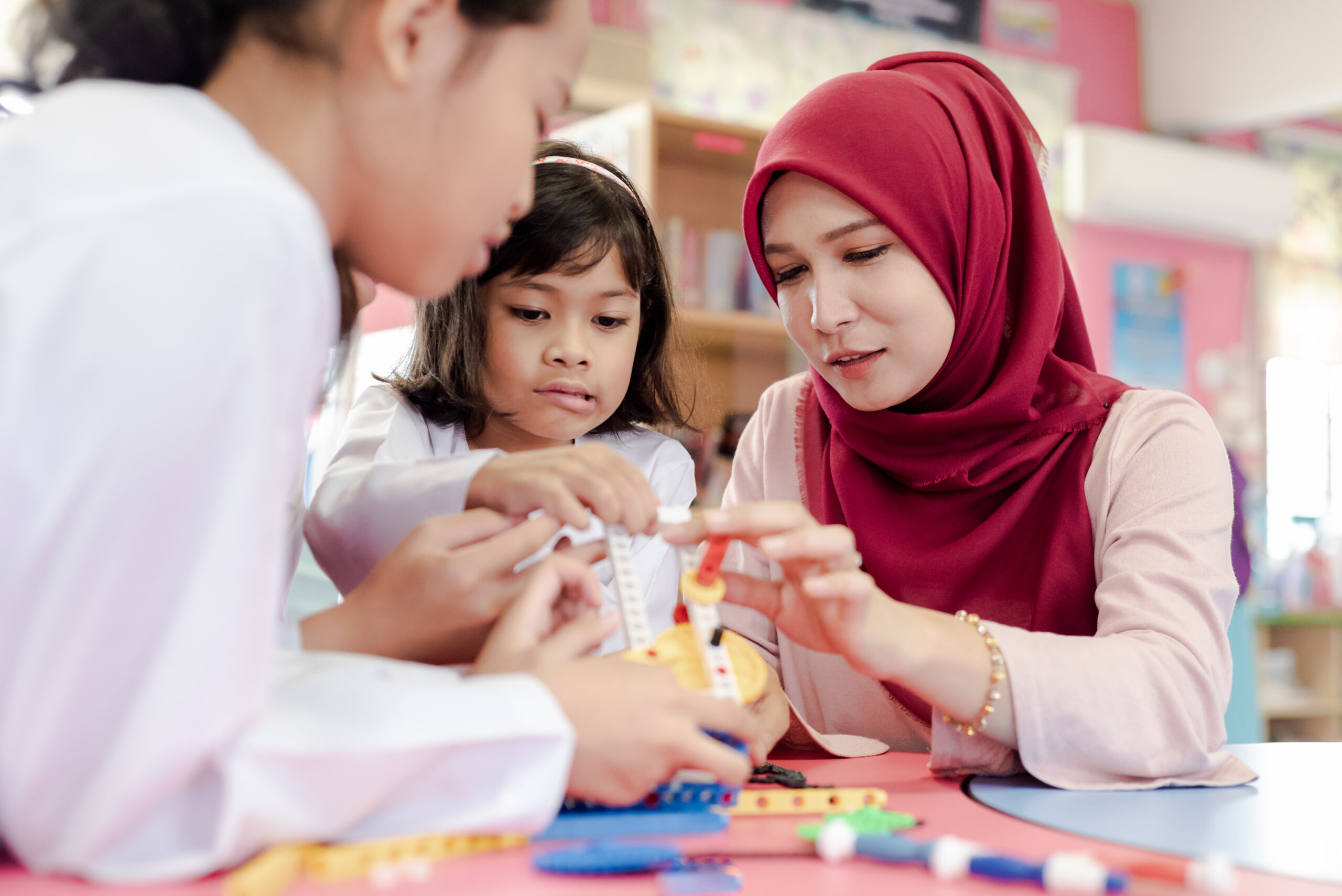 Stock image of an early childhood professional with a toddler in a childcare center setting.